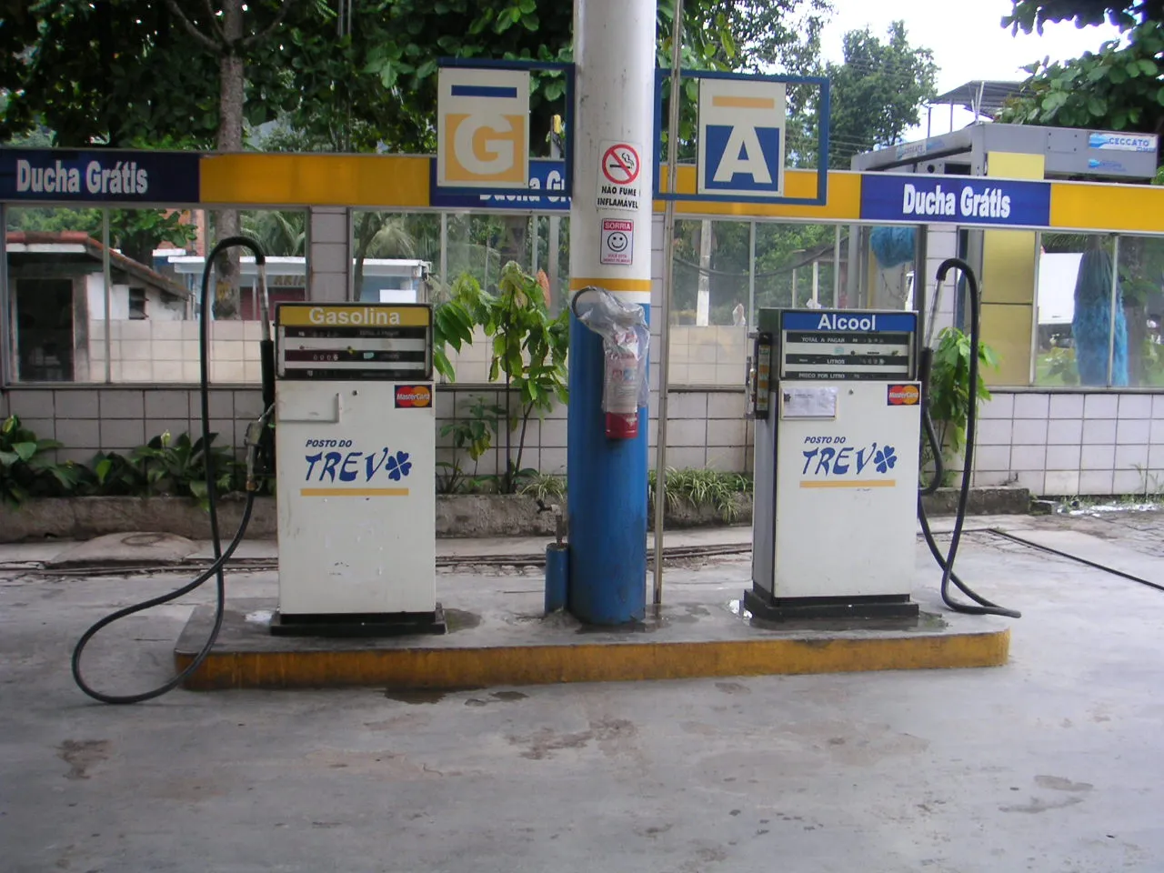 Duas bombas de combustível lado a lado em um posto, uma identificada como gasolina e a outra como álcool