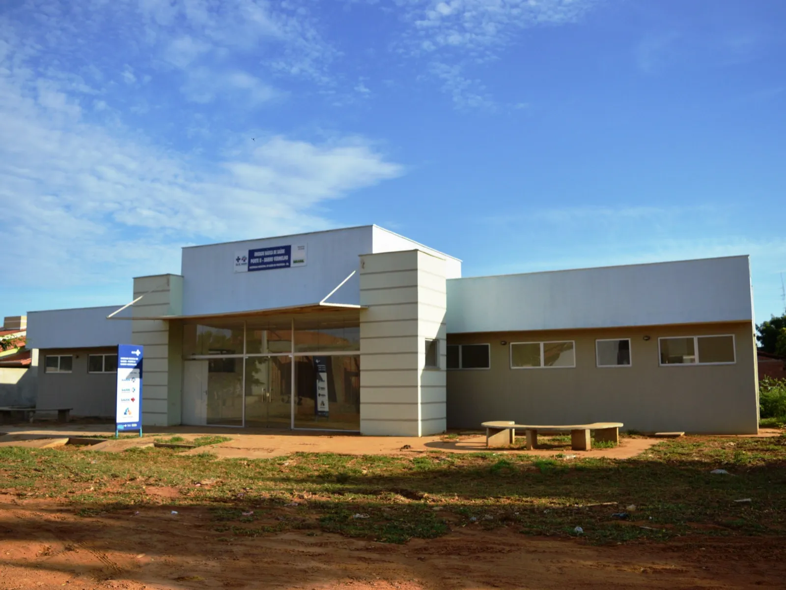 Fachada de uma Unidade Básica de Saúde térrea em uma rua de terra